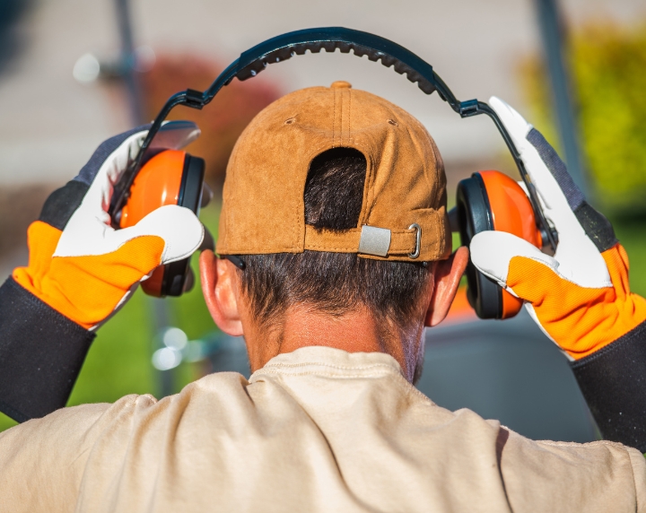 Travailleur mettant un casque antibruit pour se protéger du bruit au travail